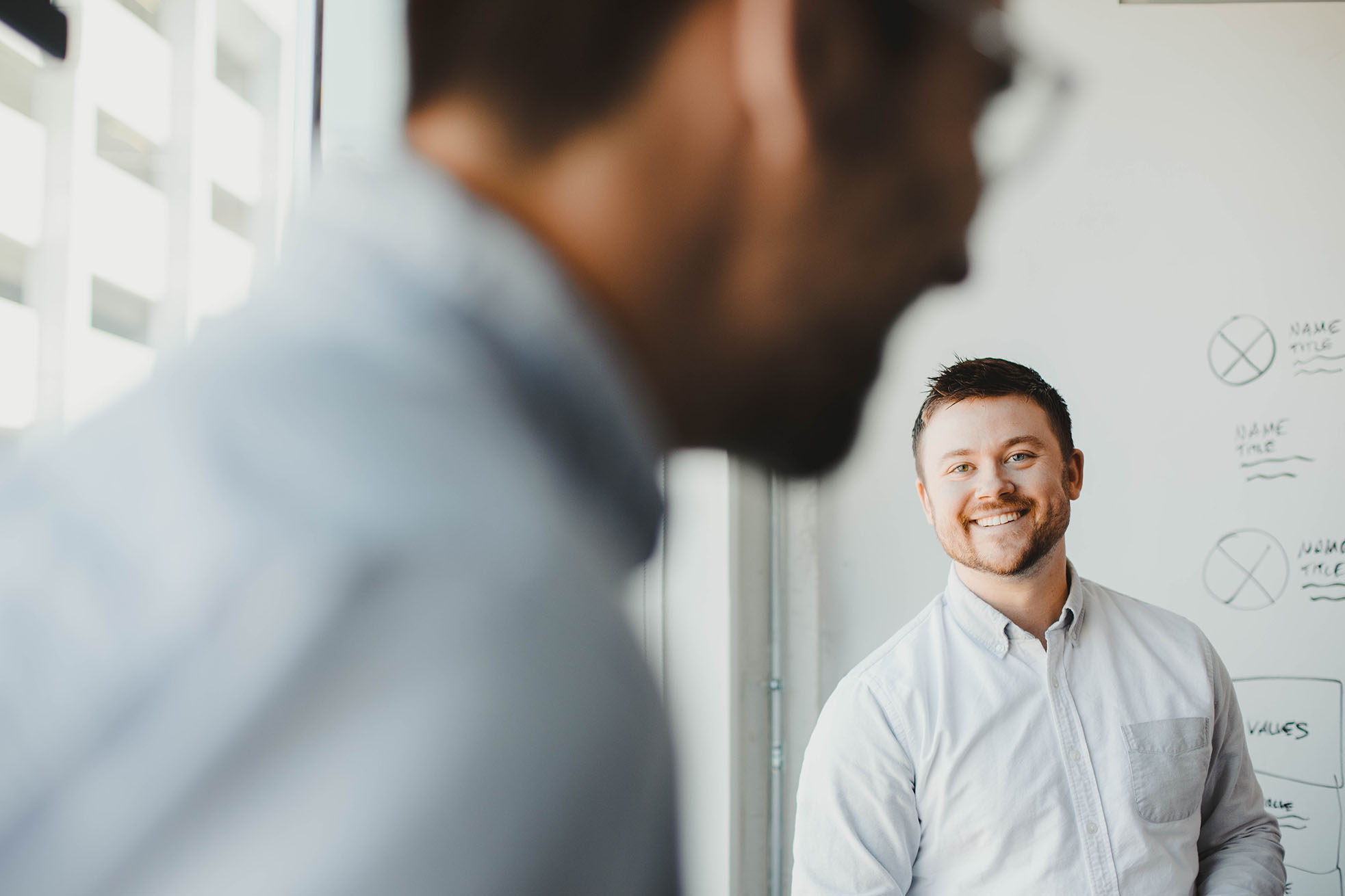 Whibaord co-founder Eric Brown smiles at a co-worker in the office.