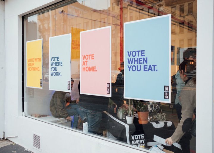 Storefront with posters that read "Vote when you eat" and "Vote where you work."