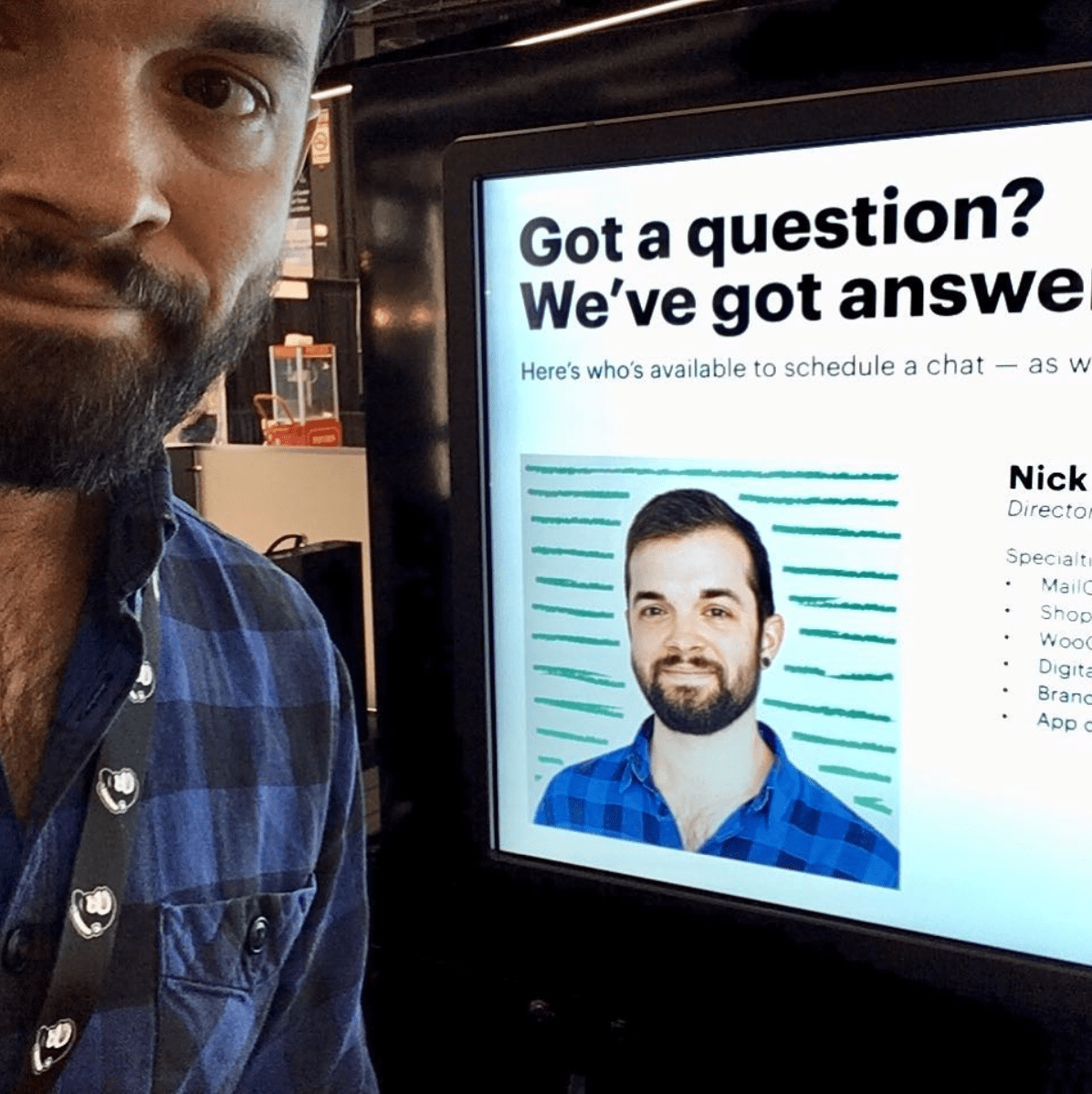 Nick Blackmon posing in front of a computer showing an article featuring his work with Mailchimp.