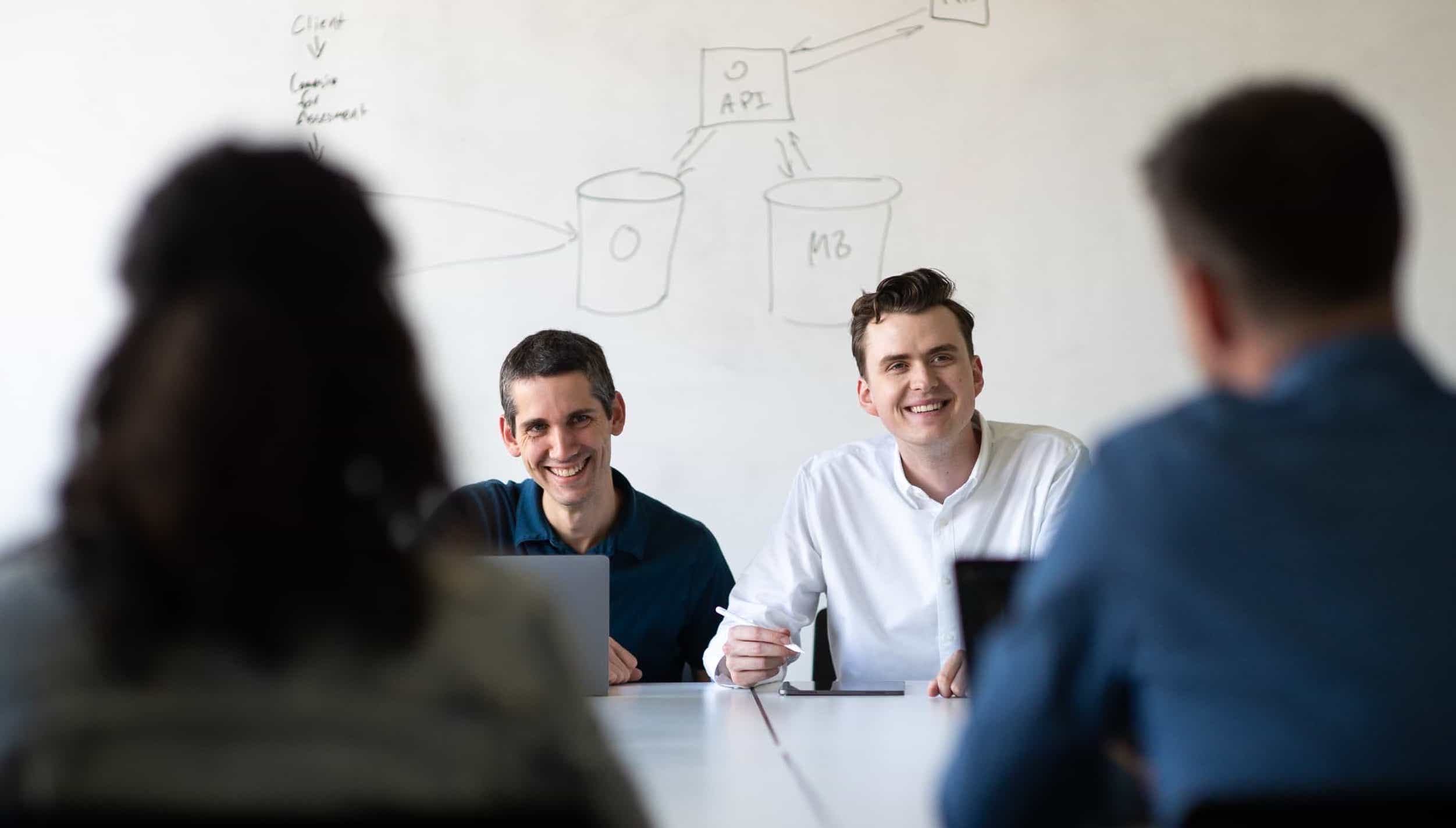 Whiteboard employees Peter Court and Matt Campbell meet with co-workers in the conference room.