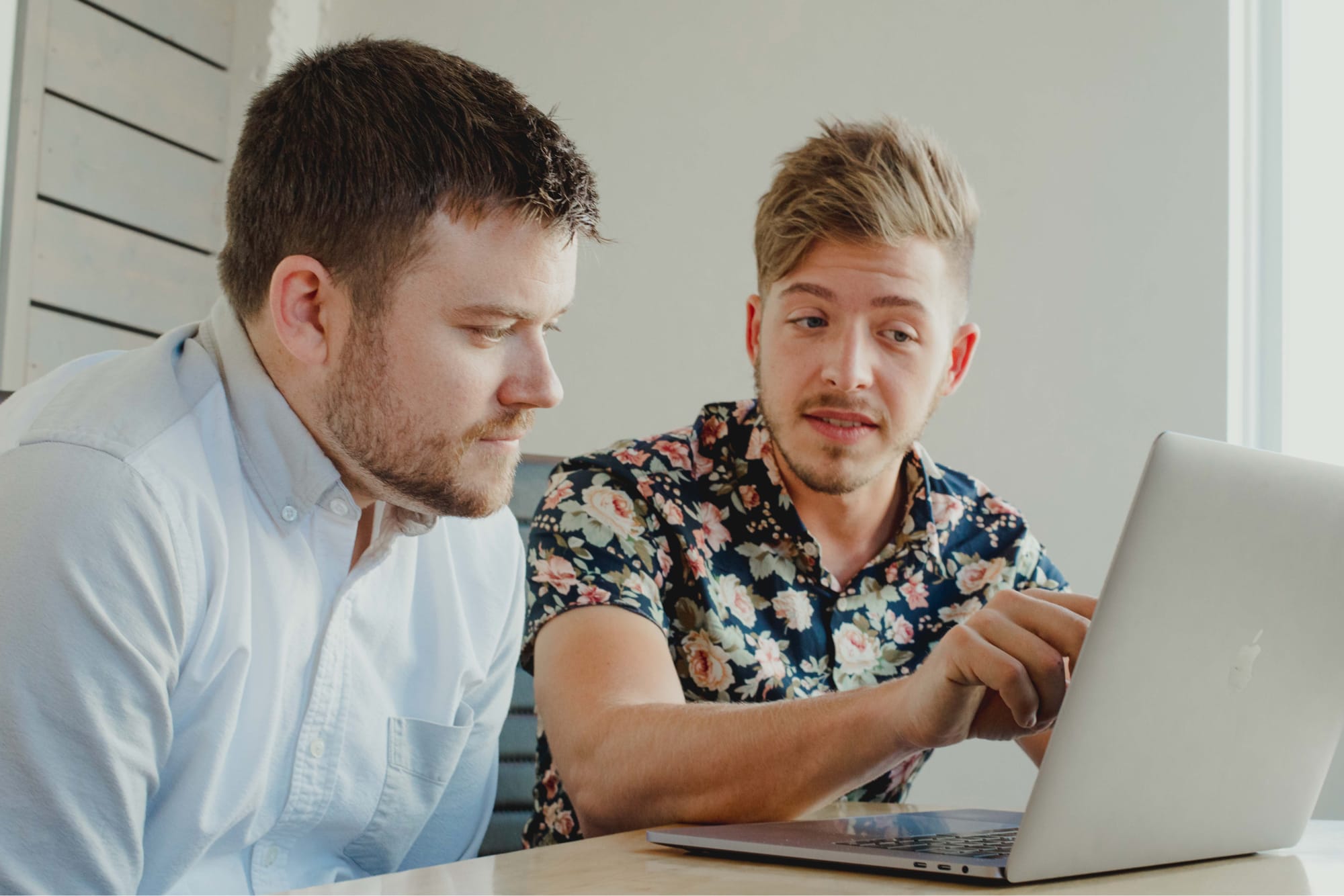 Eric Brown and Kody Dahl collaborate on a project in front of a macbook.