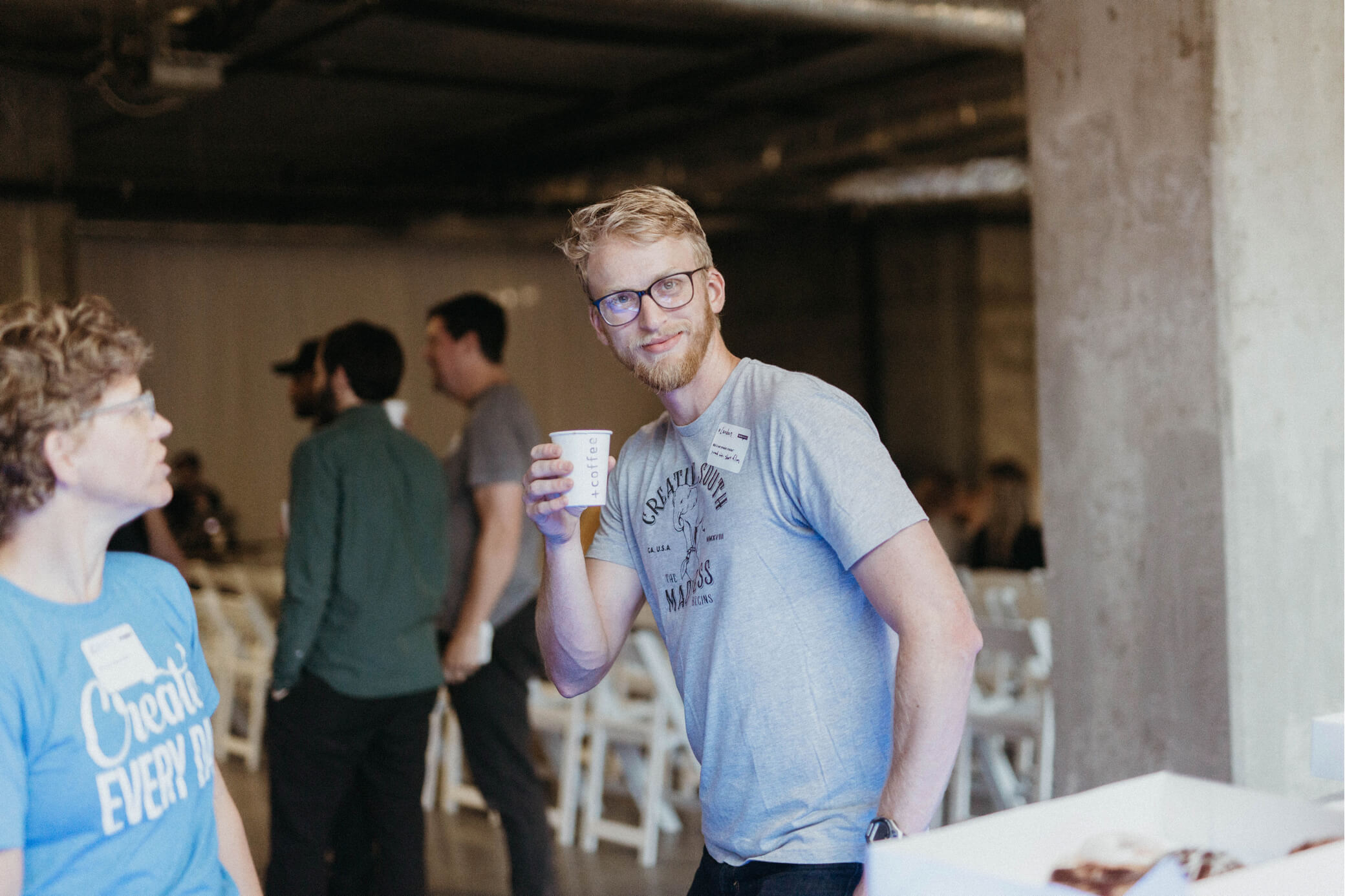 A man drinking coffee at Creative Mornings in Chattanooga.