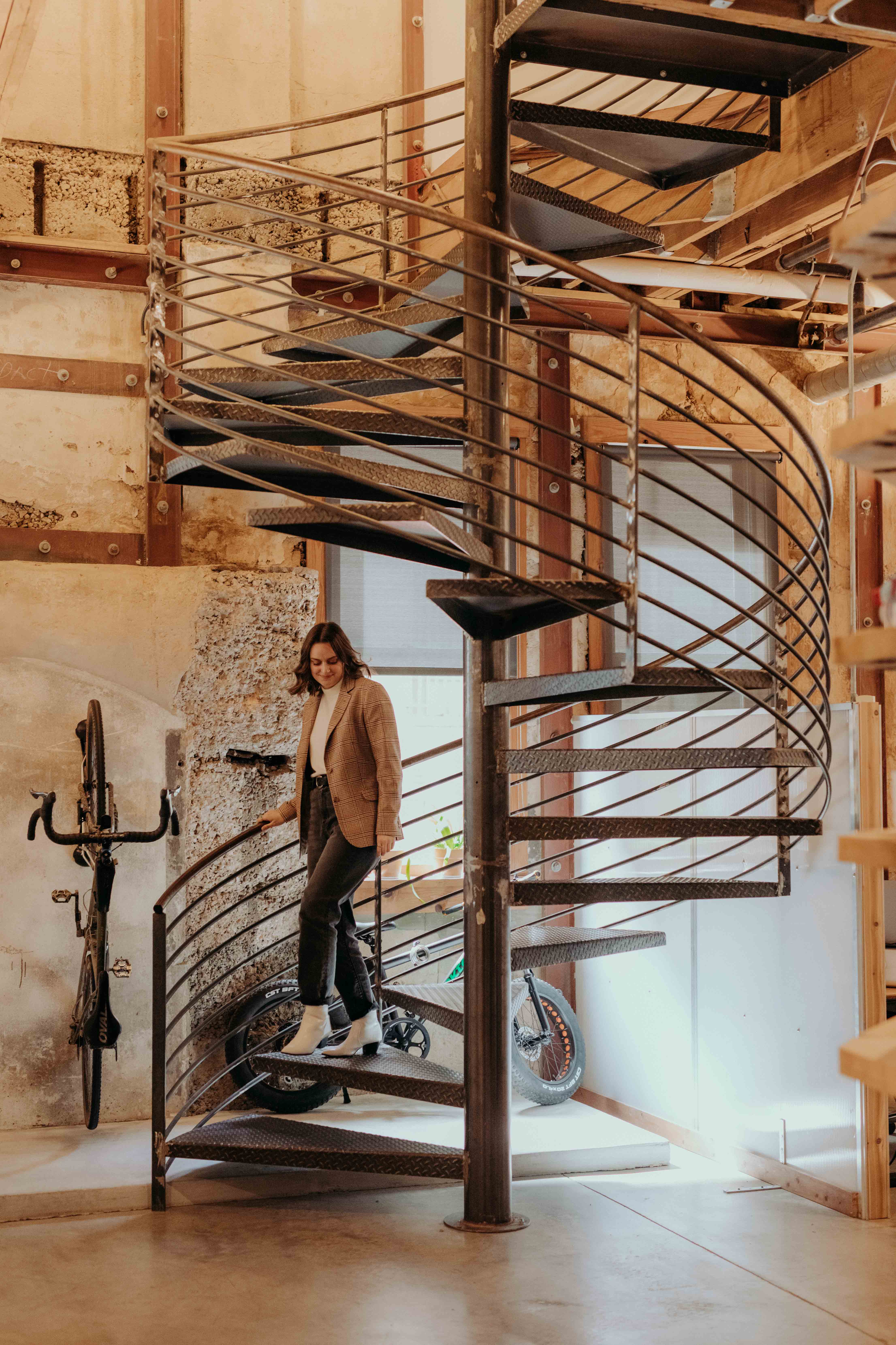 A whiteboard employee ascends the spiral staircase at the office.