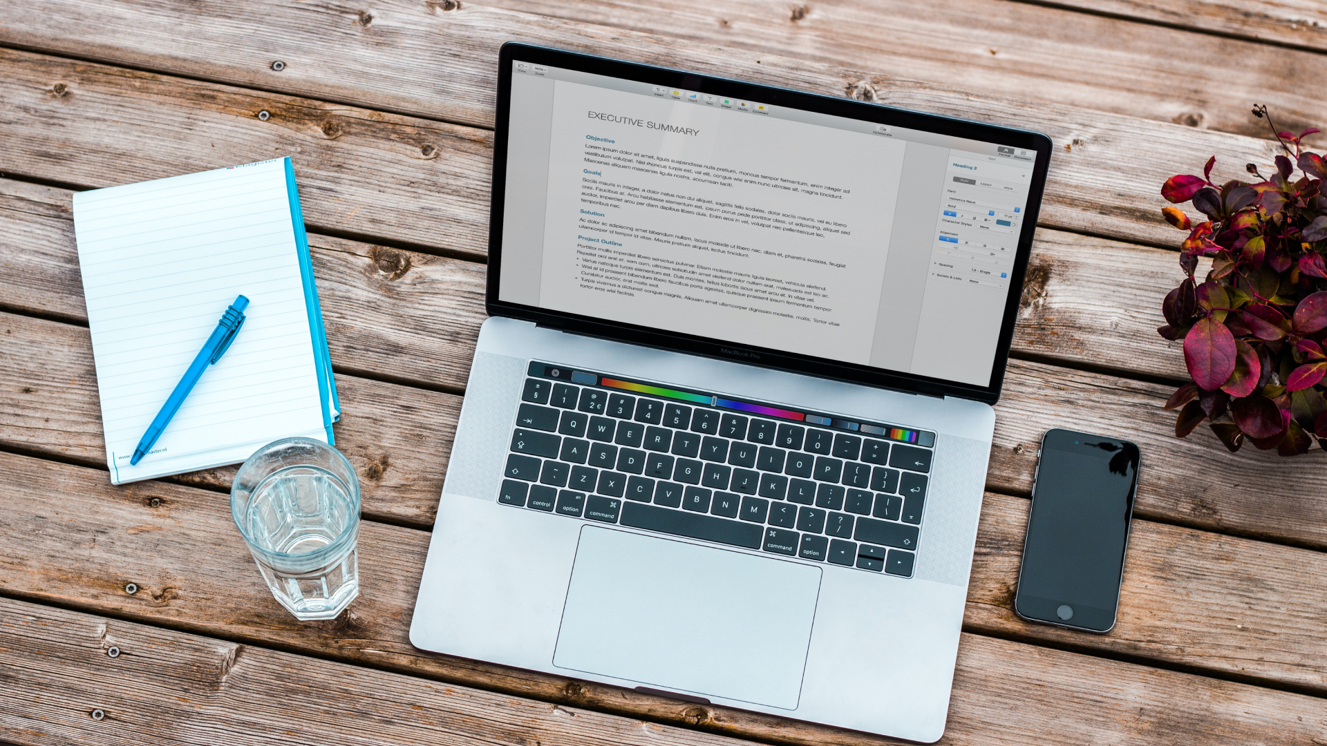A computer and a notepad on a table.