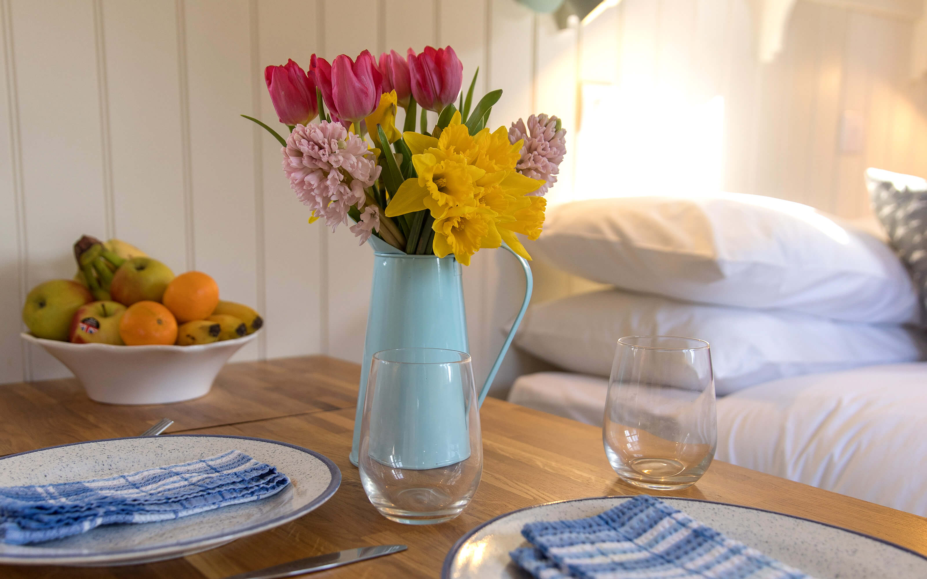 A table setting with flowers inside a shepherds hut.