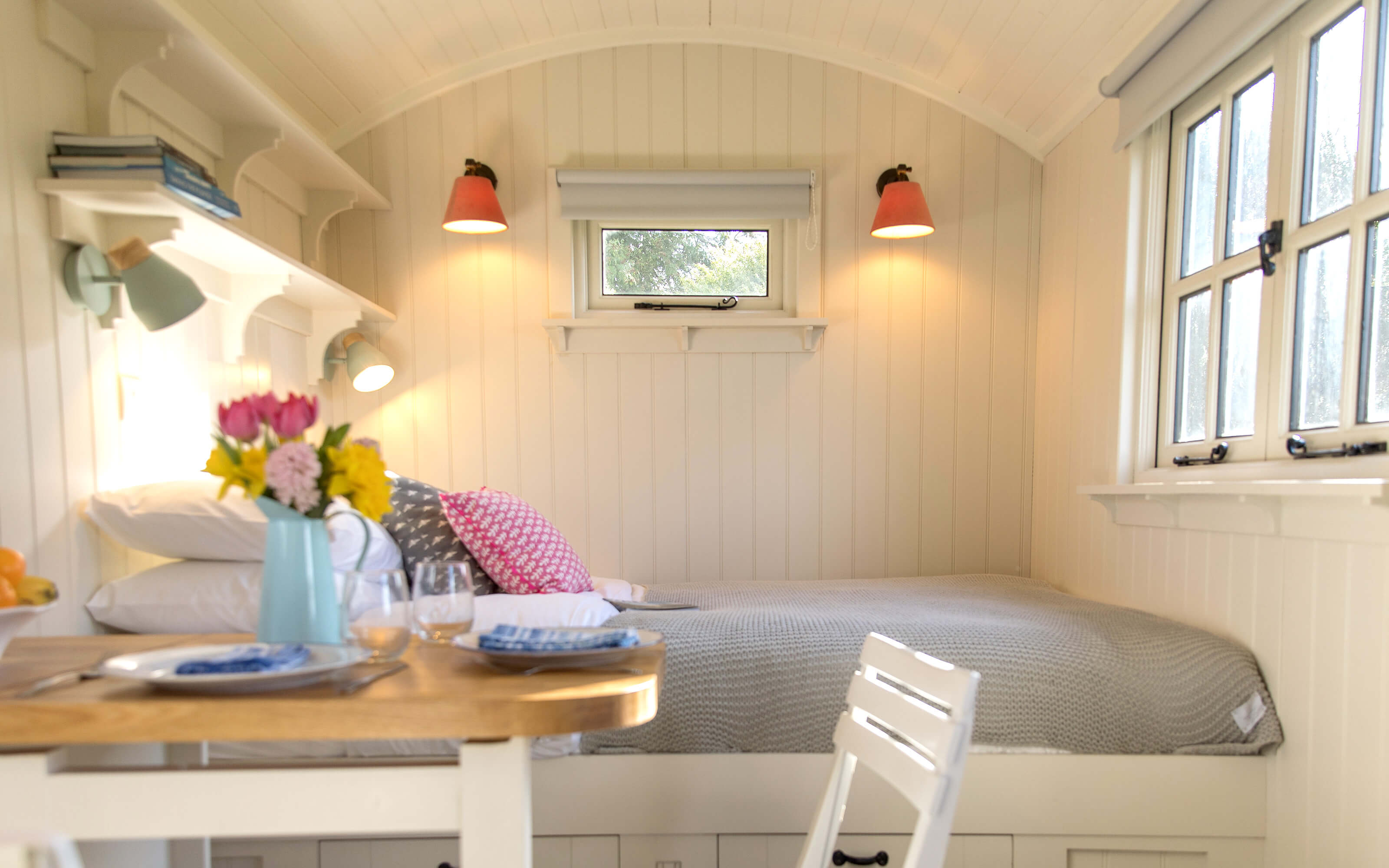 The king sized bed inside a shepherds hut.