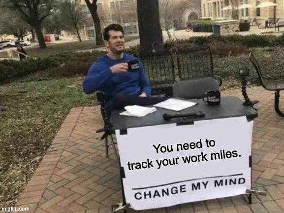 Man sitting behind a table with a sign that says "You need to track your work miles. CHANGE MY MIND."