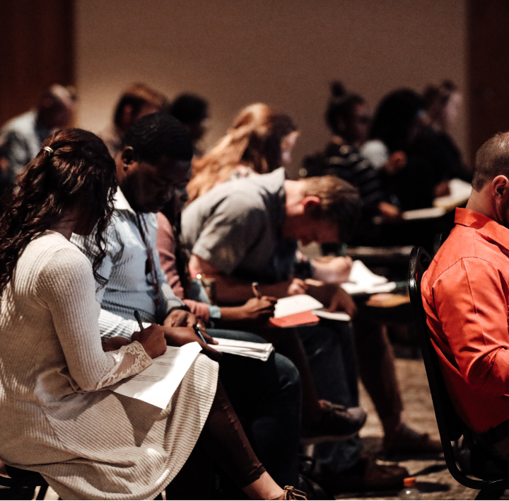 group of young people taking notes