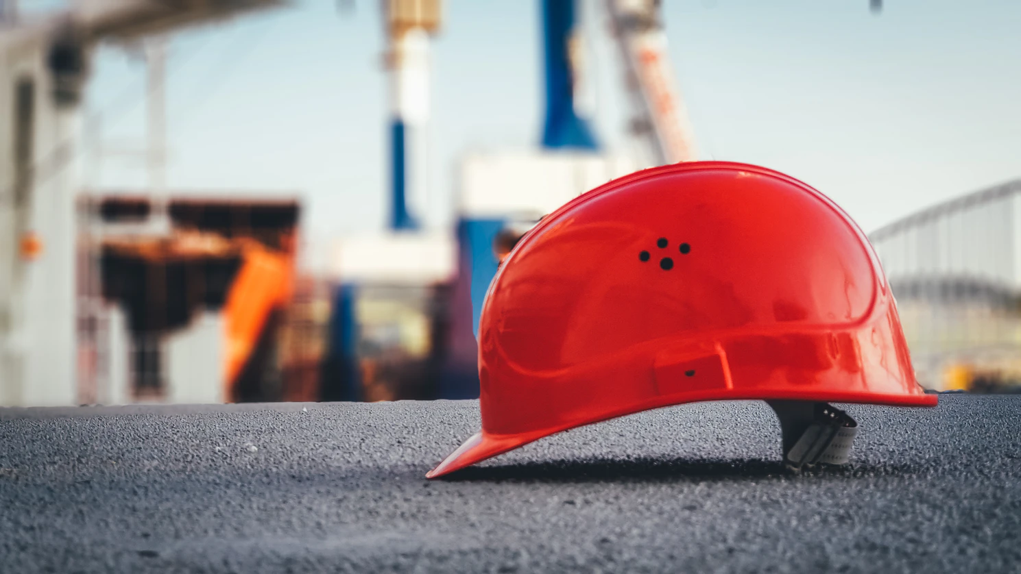 Red construction hat on floor of construction site