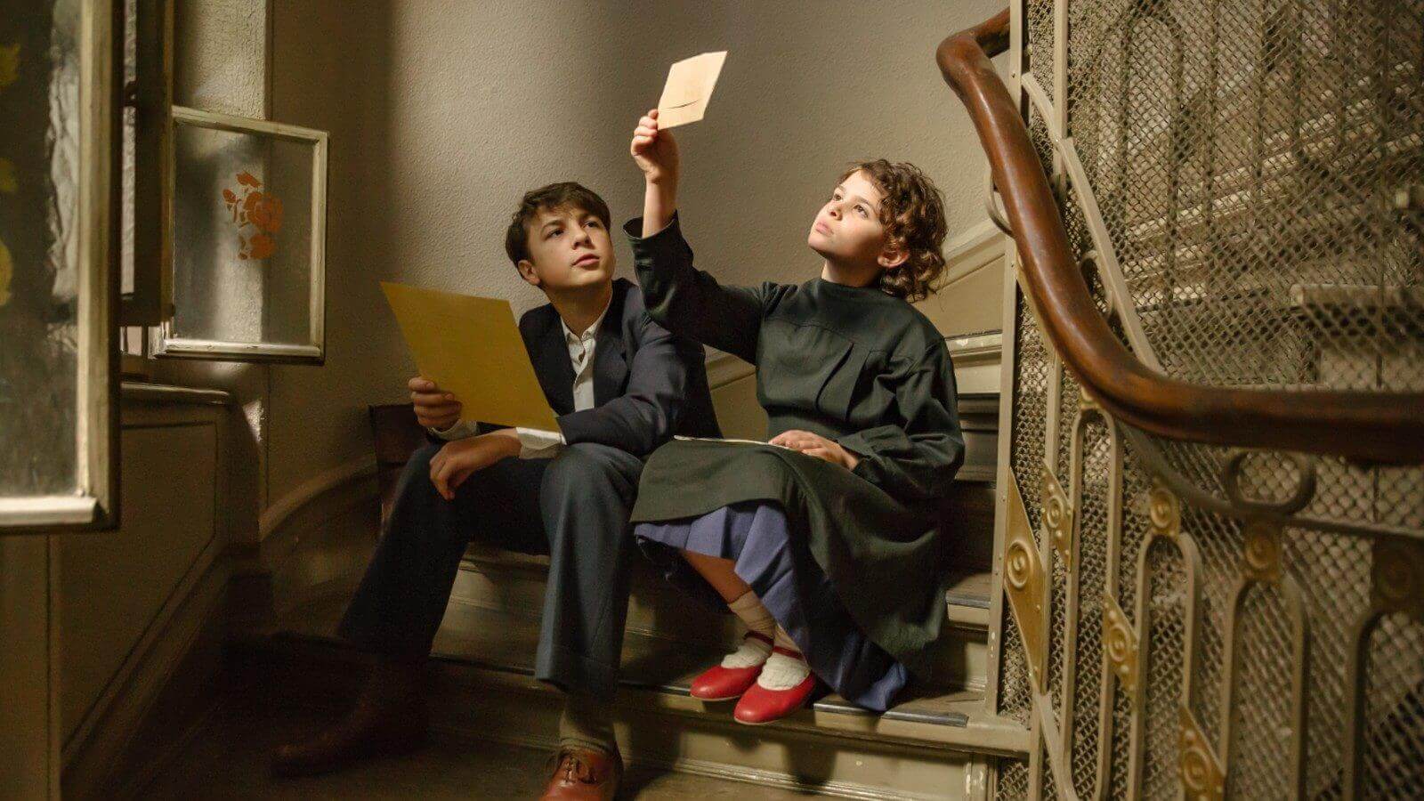 still from movie, wo children looking at papers