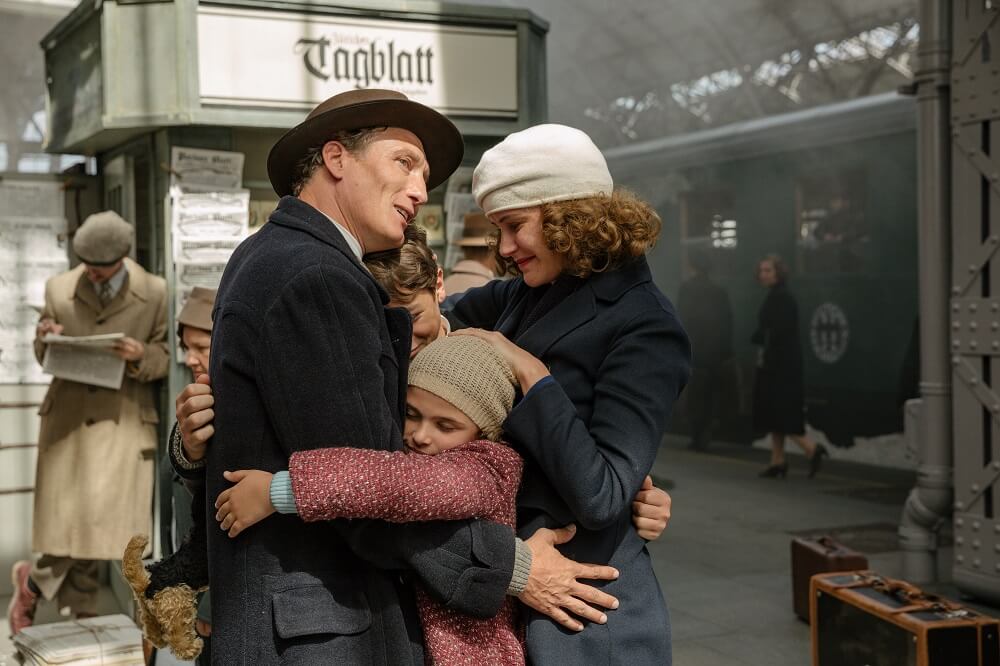 family embracing at train station