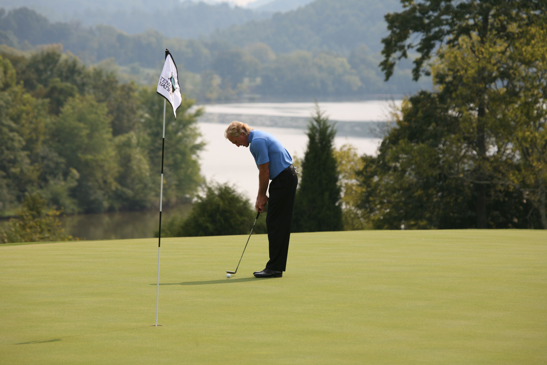 Greg Norman golfing at Tennessee National with Lake in Background