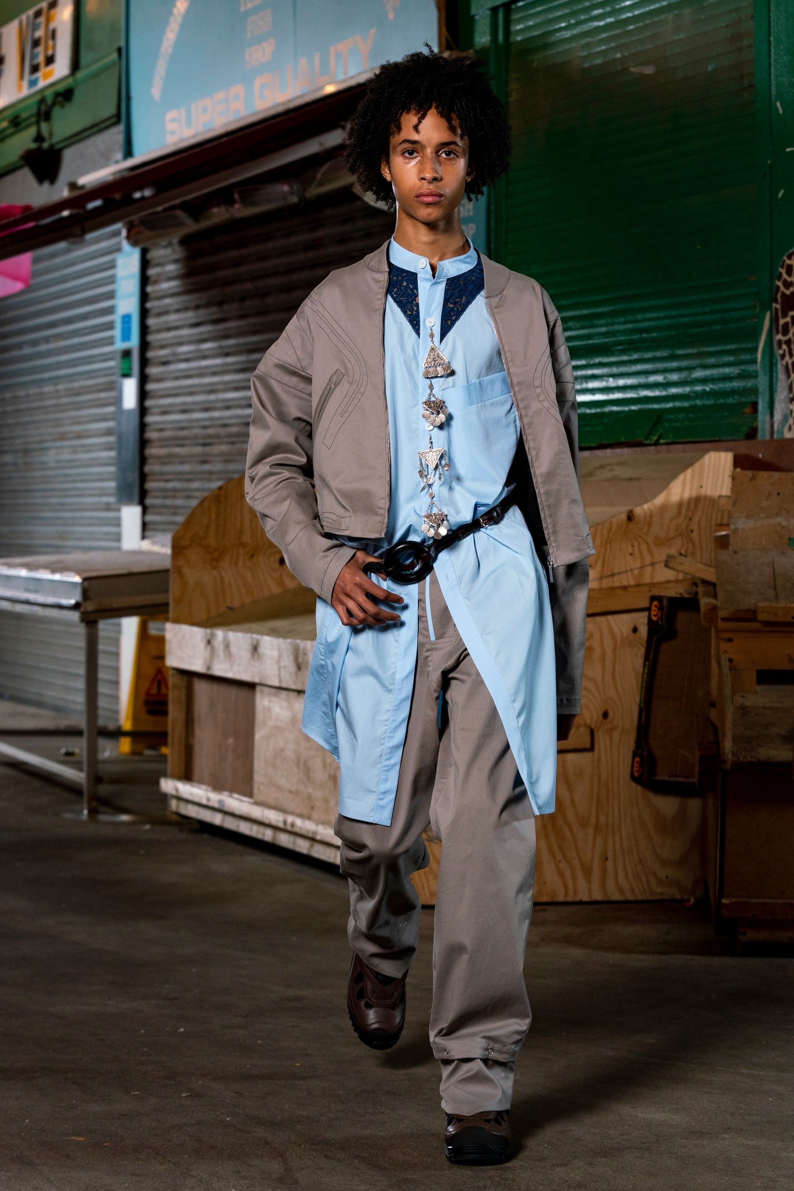 Image may contain Clothing Apparel Wood Human Person Plywood Coat Overcoat Footwear Shoe Sleeve and Long Sleeve