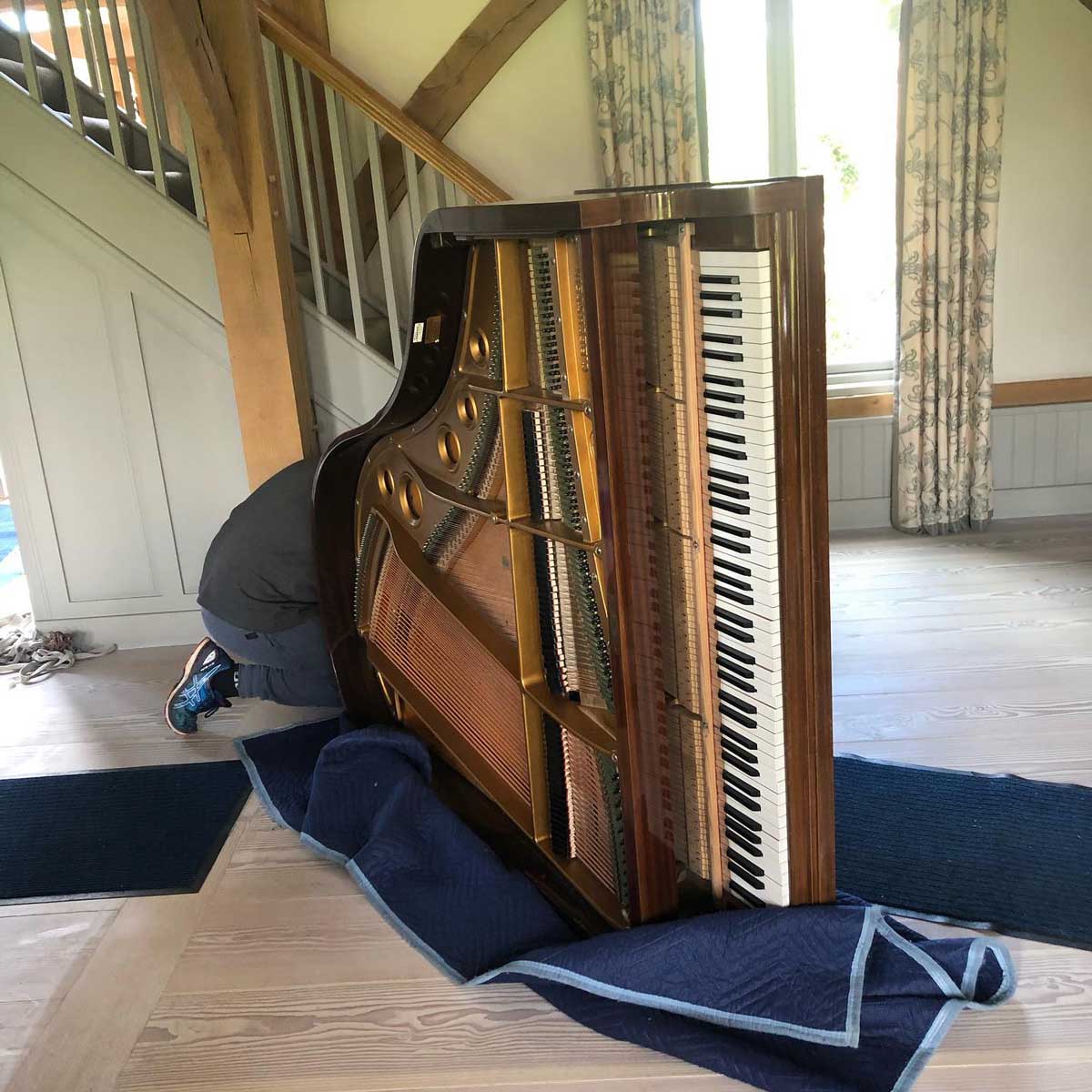 A grand piano being wrapped