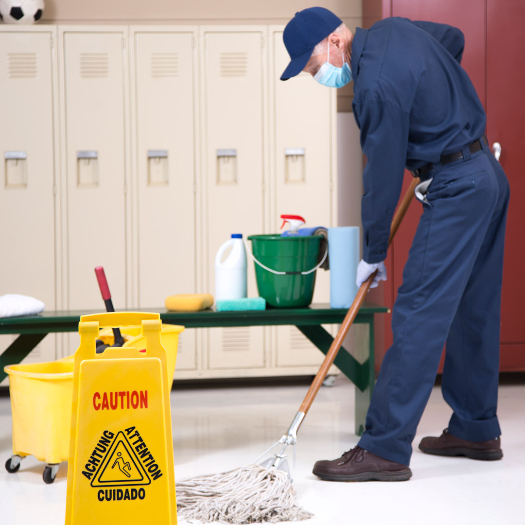 School custodian moping floor of locker room.