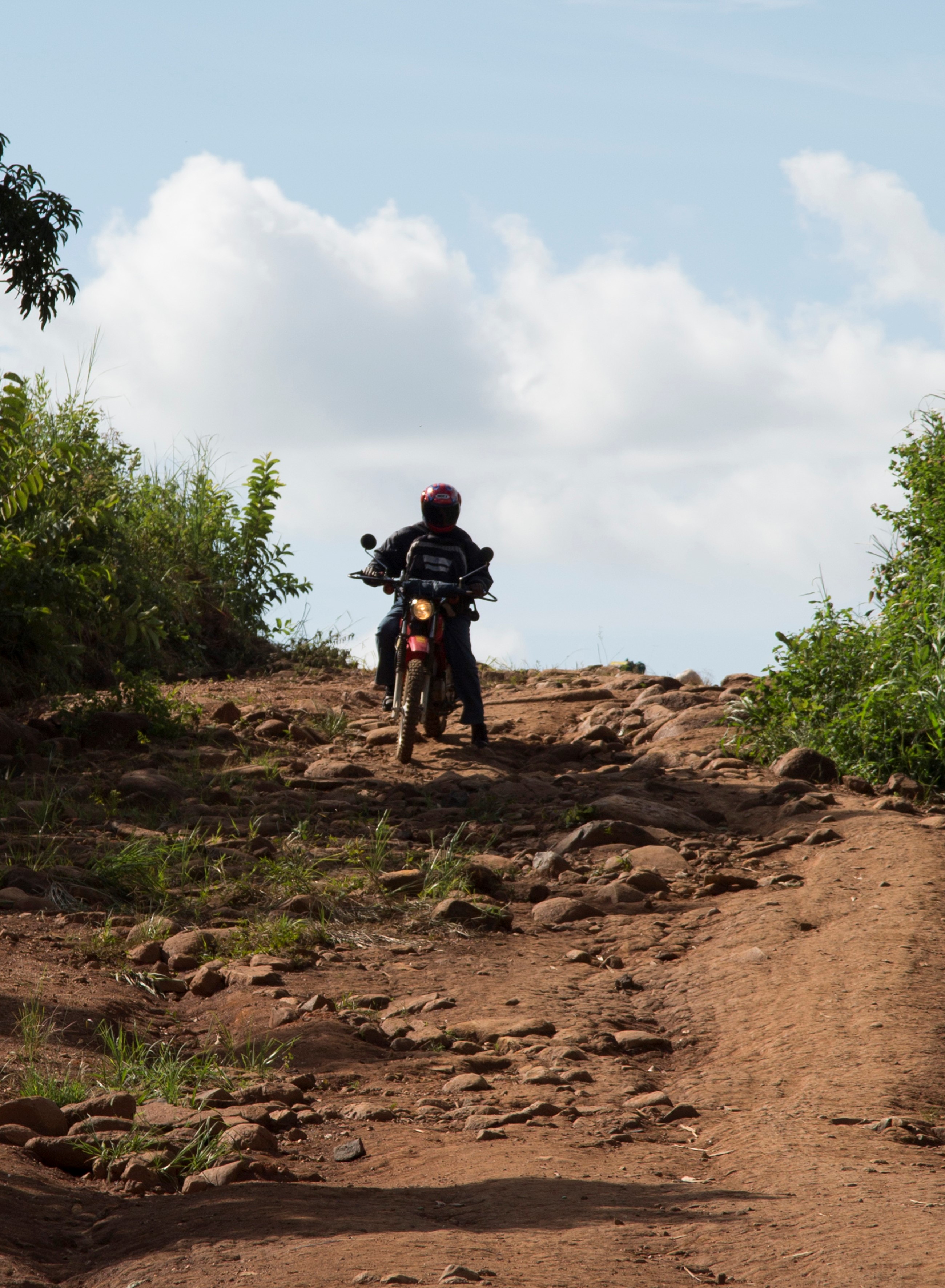 community health worker on motorbike on rural road