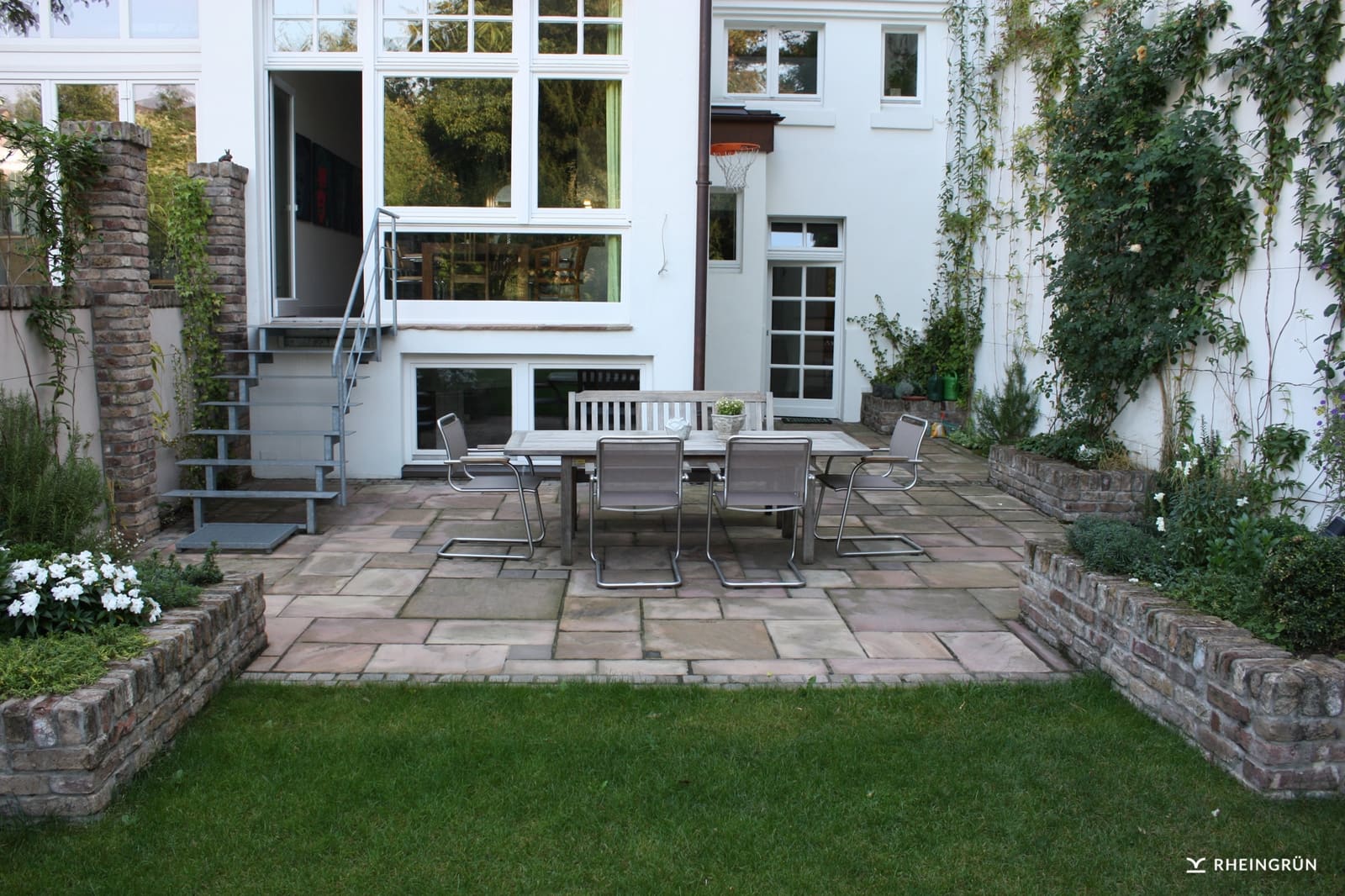 Klassischer Garten in Hinterhof mit Terrasse aus Naturstein und