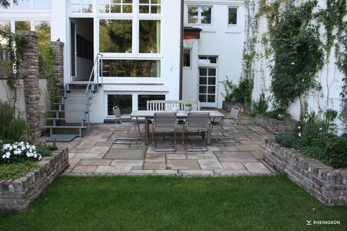Klassischer Garten in Hinterhof mit Terrasse aus Naturstein und
