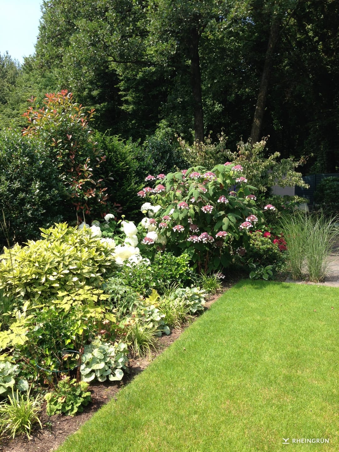 Klassischer Hausgarten mit Teich und großer Terrasse aus Naturstein