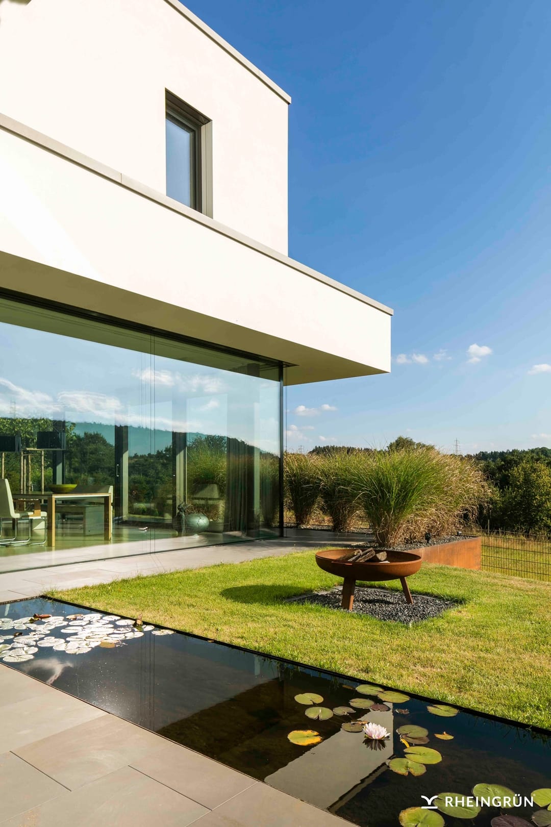 Minimalistische Gartengestaltung am Hang mit Wasserbecken aus