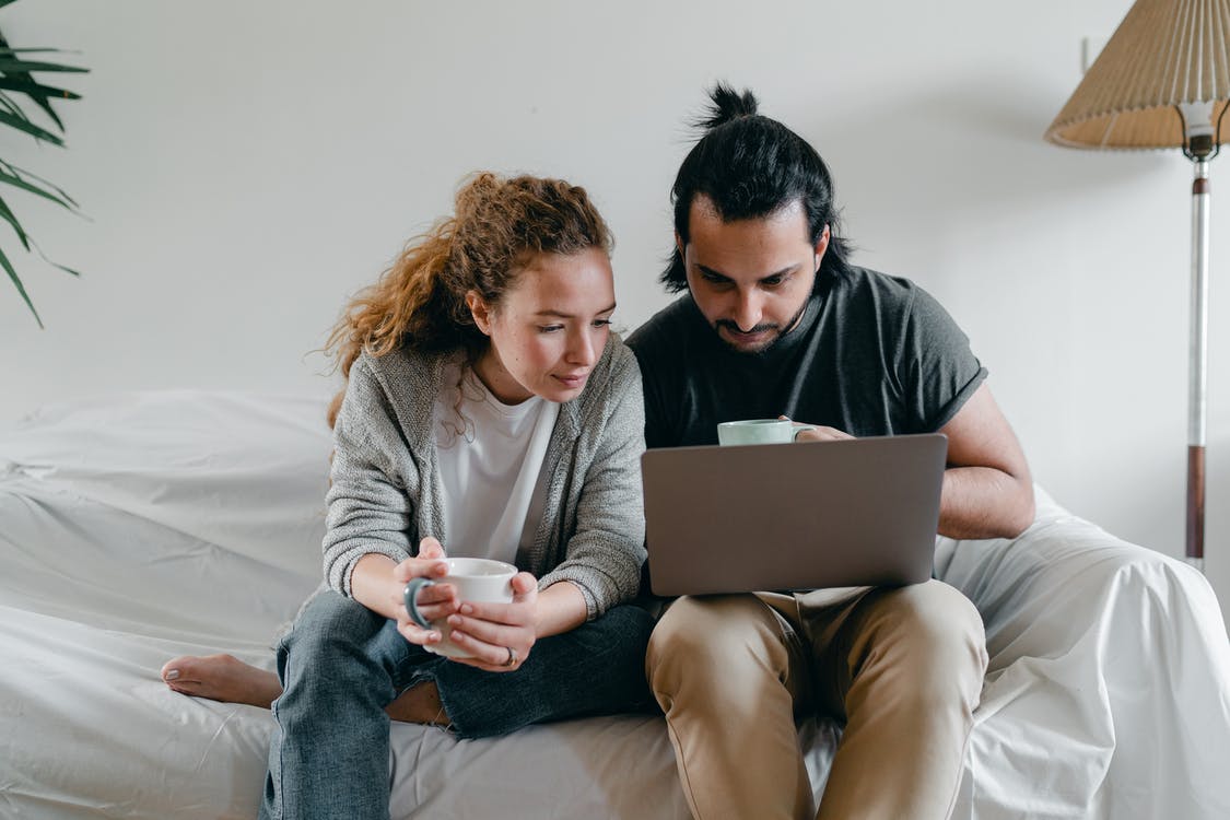 Photo de deux personnes devant un ordinateur