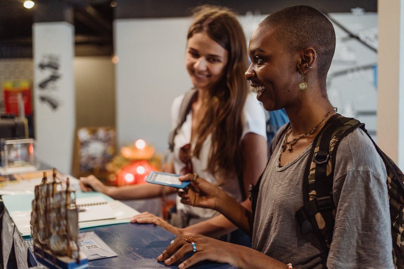 Two happy women checking in at a hotel reception