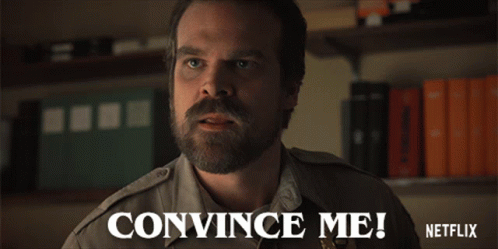 “The character named Jim Hopper from the Netflix series ‘Stranger Things’ is shown in uniform asking someone to convince him of something with the captioning, ‘Convince Me!’”