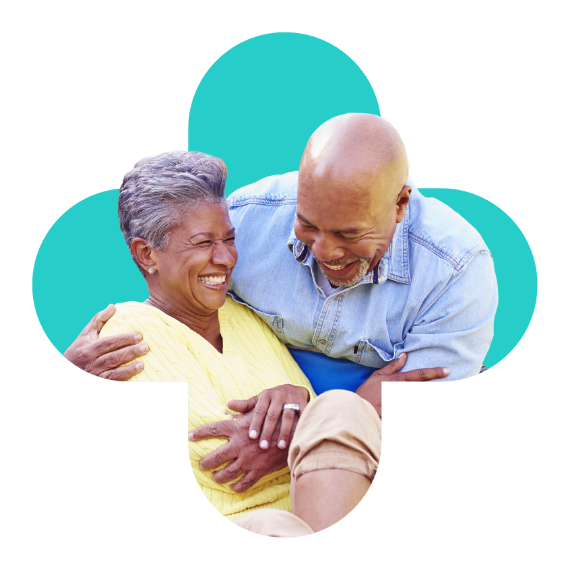 An elderly couple embracing and laughing