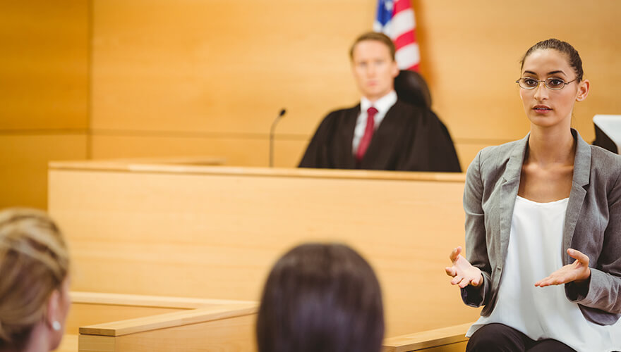 Woman using sign language in front of a judge in a courtroom