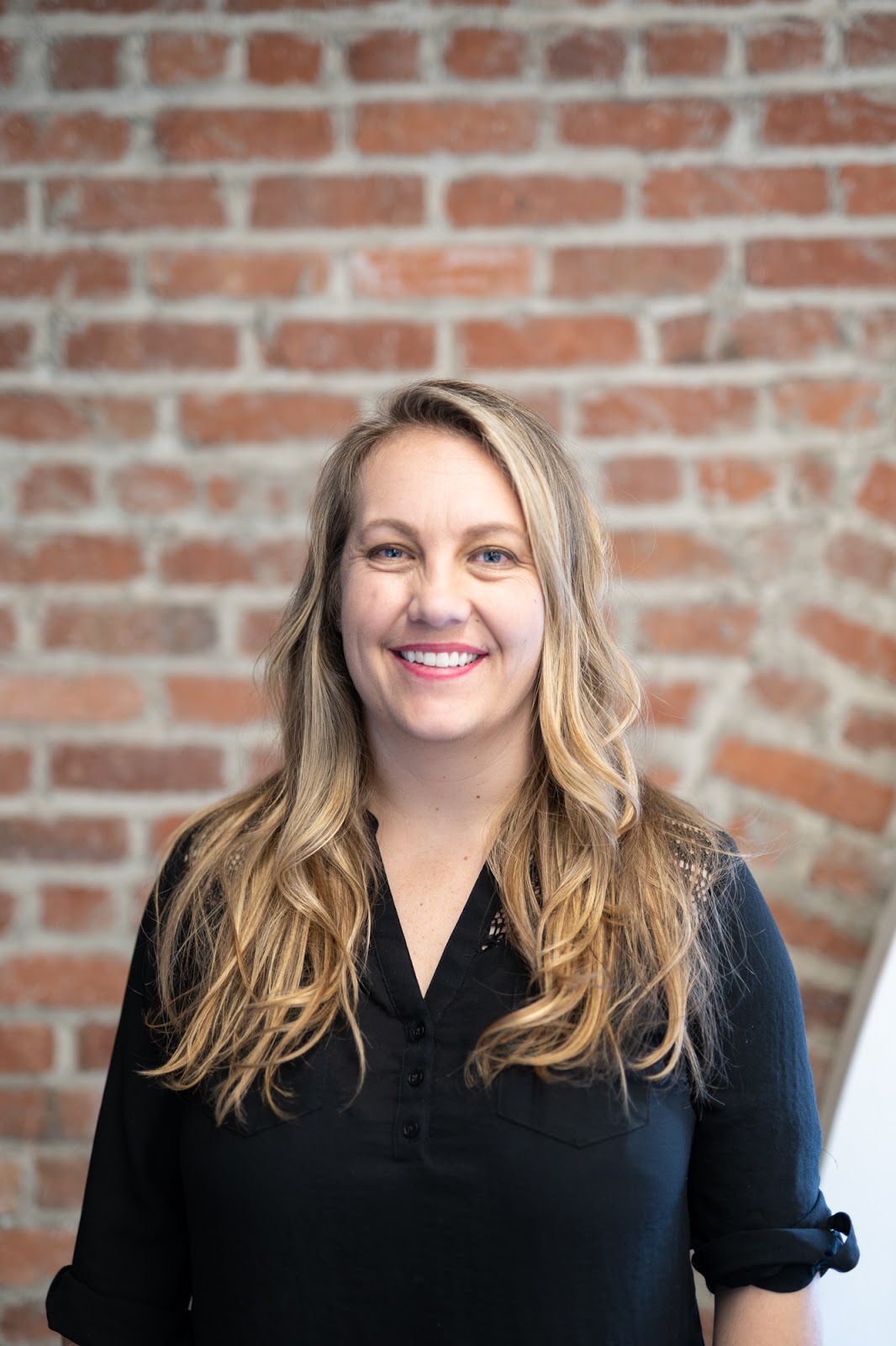Christy's headshot in front of a brick wall