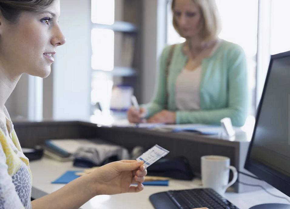 Receptionist checking an insurance card