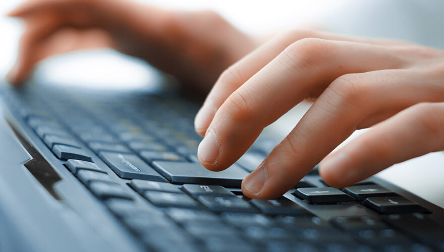 Person typing on a computer keyboard
