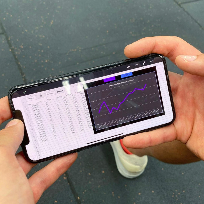 An athlete reviewing their velocity based training data on a phone
