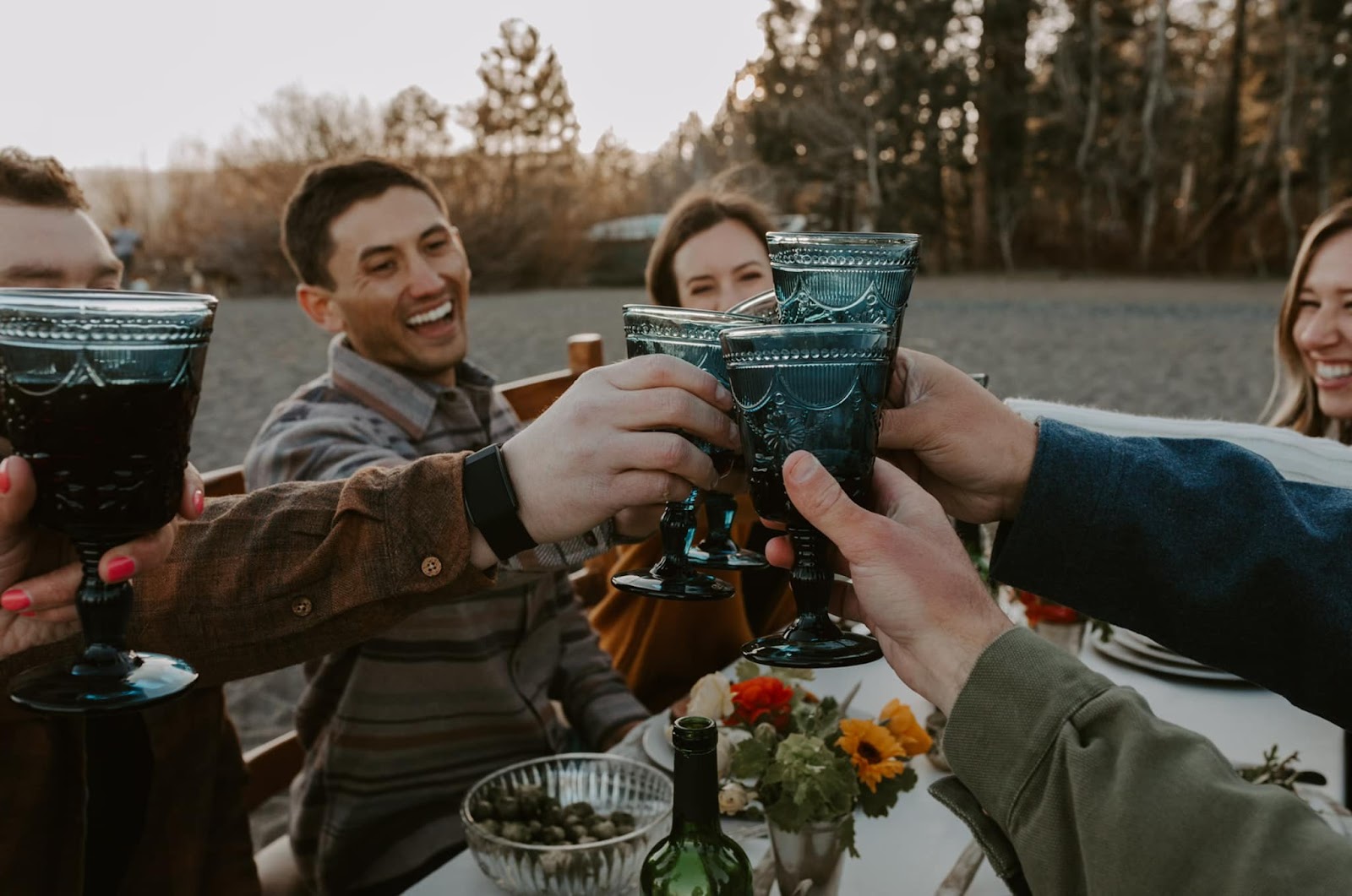 Group of friends dressed in Grizzly Menswear apparel raising glasses in a toast.