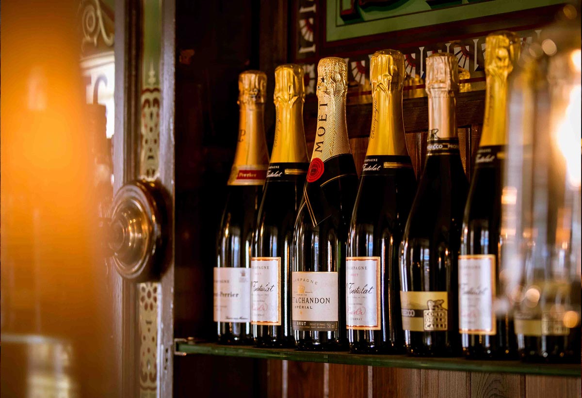 Pub Photography. Champaign bottles with out of focus vintage lamps in the foreground