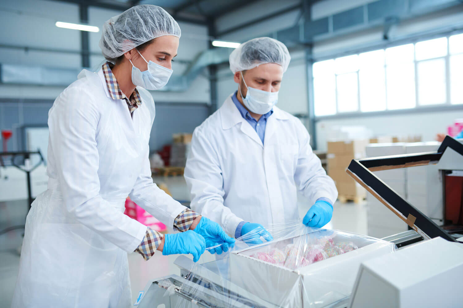Workers with face mask packaging product with wrapper