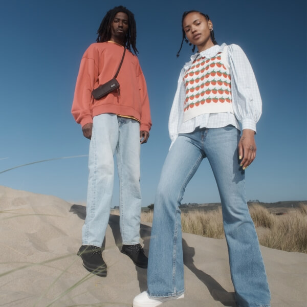 Two models wearing Levi's on a sand dune