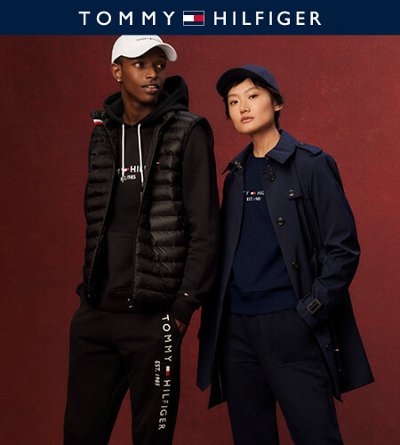 Two models wearing Tommy Hilfiger apparel - one in all black and a white hat, the other in all navy