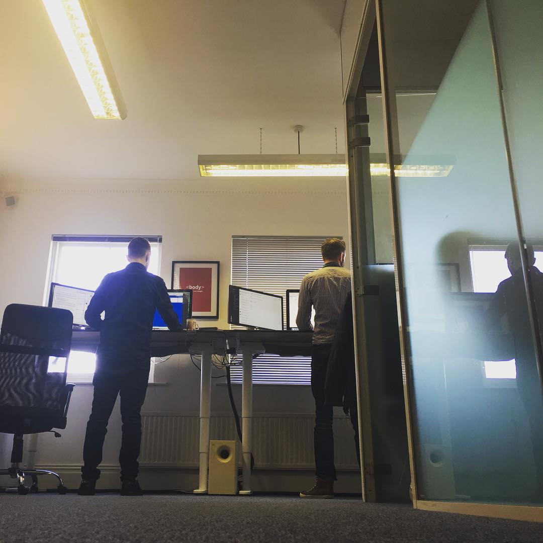 Dave and Matt standing at their standing desks