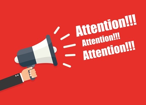 Megaphone being held with text: "Attention!!!" being omitted from the device. Text repeated three times