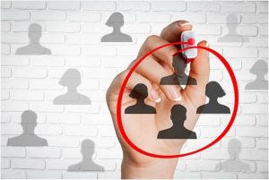 Hand using a marker to circle four generic profile-picture silhouettes