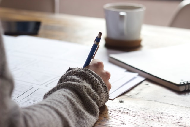 woman writing on desk