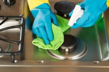 Hands cleaning the stove
