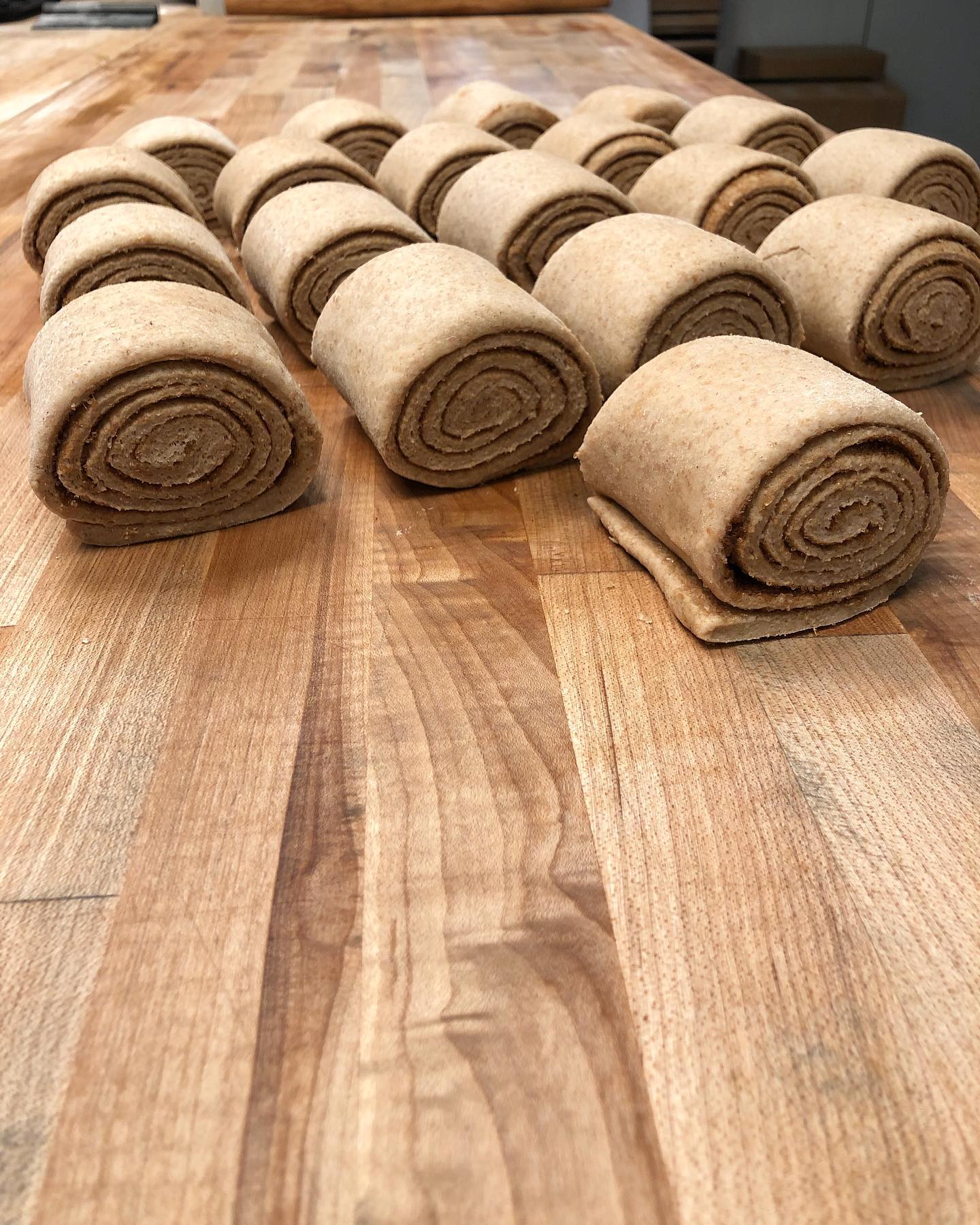 vegan cinnamon buns being rolled ready for baking