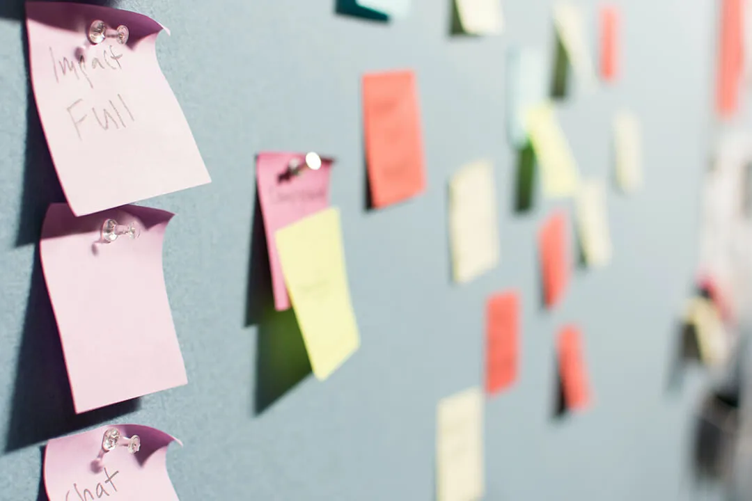 Colourful post it notes on a grey wall