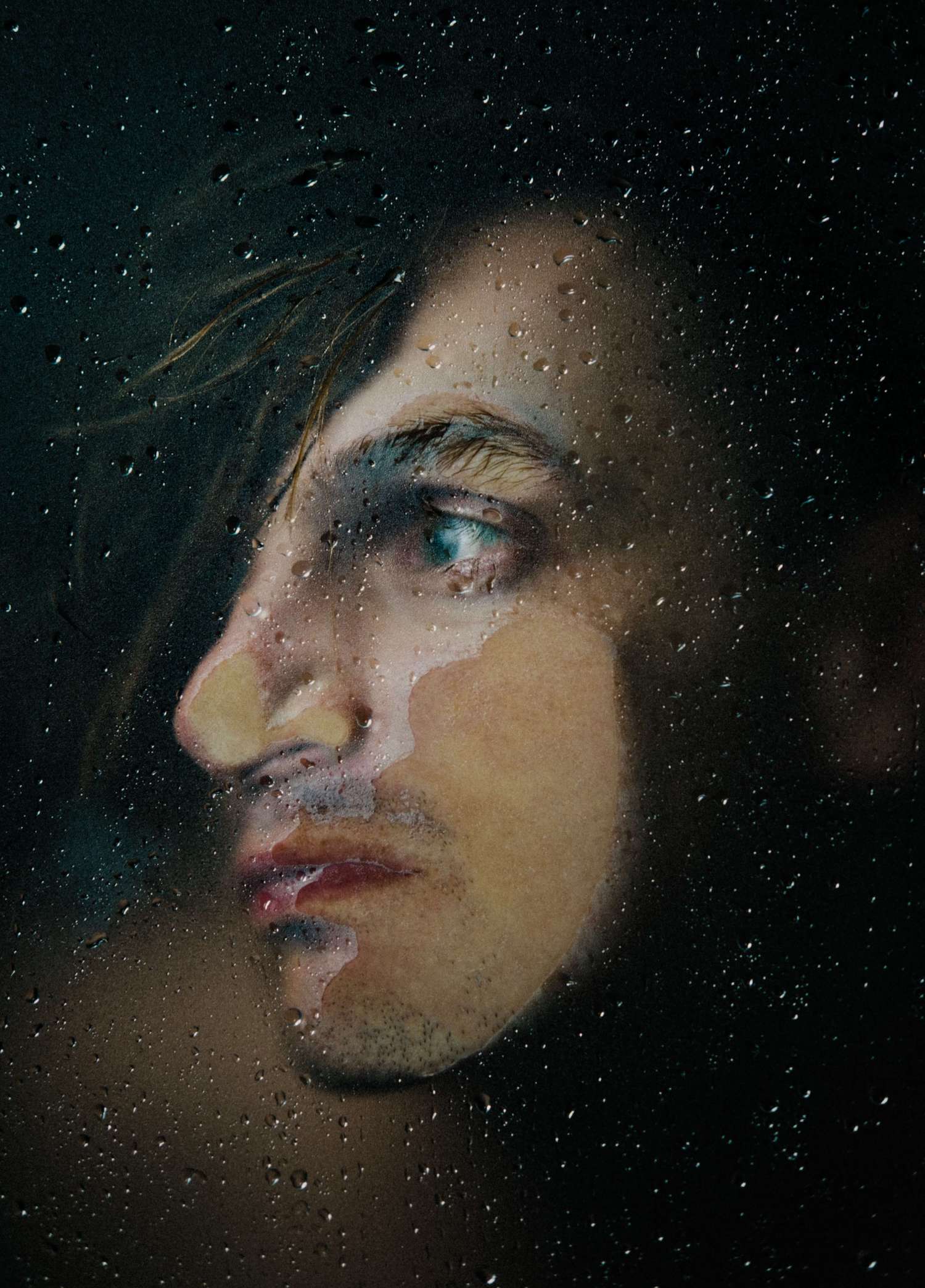 Portrait of a man through a rainy window.