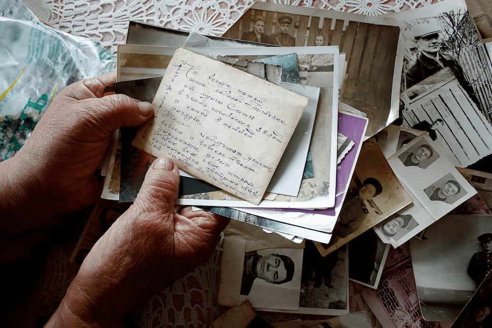 Hands of grand mother with letters and old photos in Belarus by photographer Krystsina Shyla