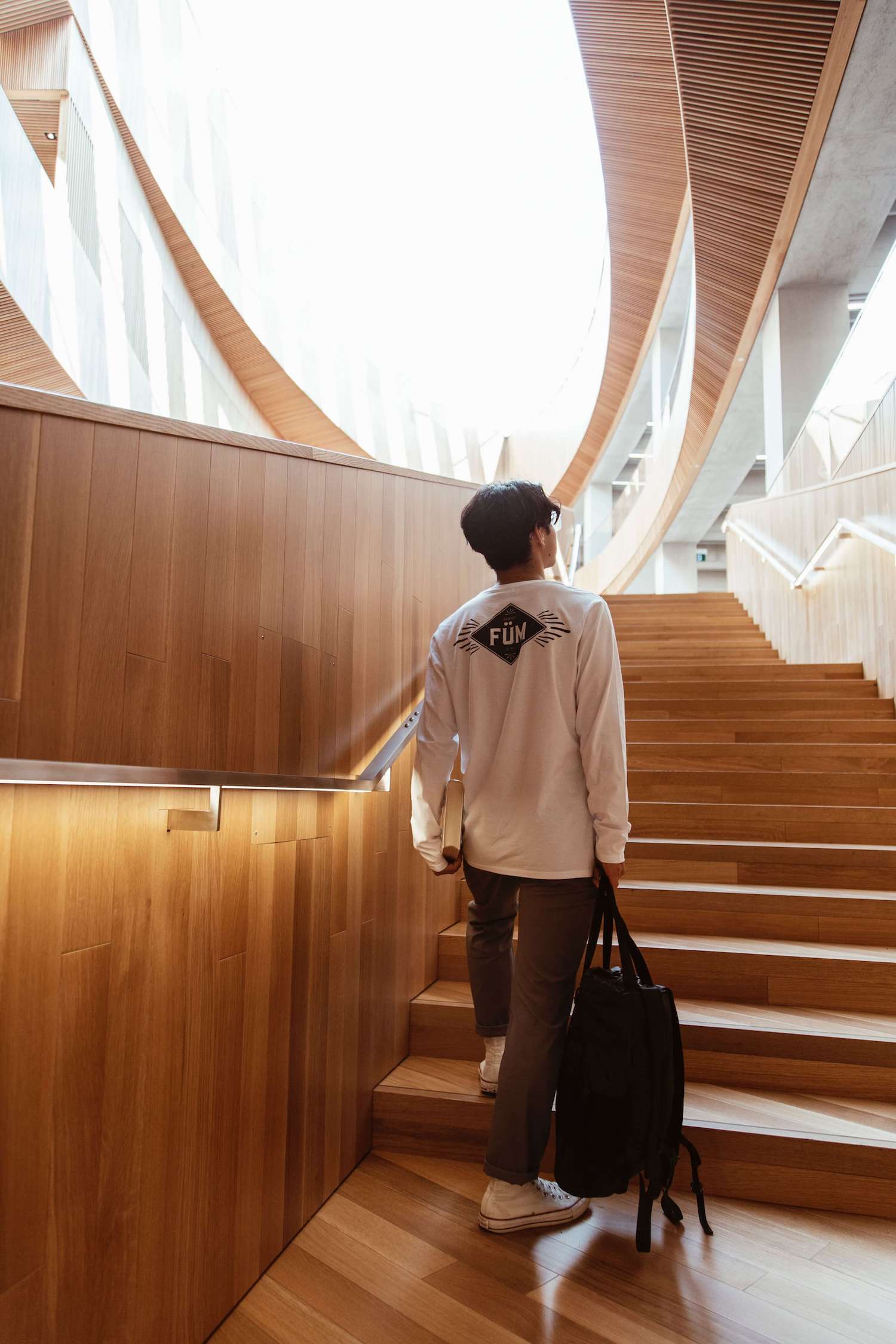 A young man going upstair in a modern designed library.