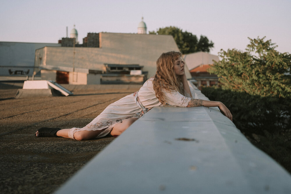 Portrait of girl on a rooftop in Berlin with sunlight boheme style by photographer Krystsina Shyla