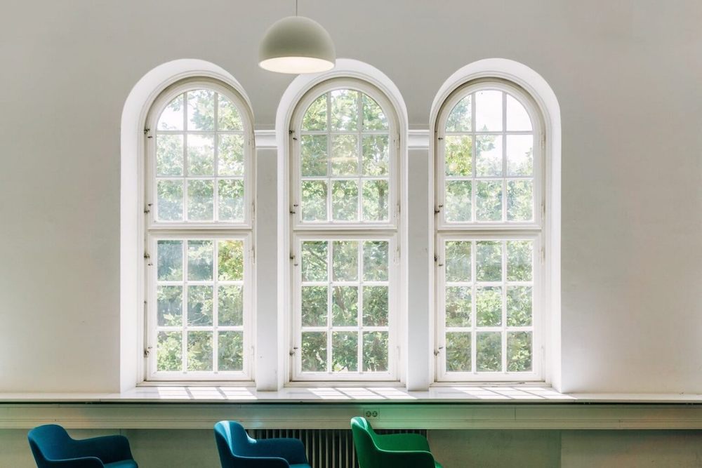 Interior of a bright room with three large windows.